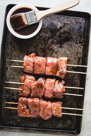 hoisin marinated pork kababs ready for the grill on a baking sheet