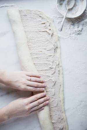 2 hands rolling Cardamom Rolls with Almond Glaze