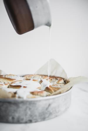 Cardamom Rolls with Almond Glaze being poured over top