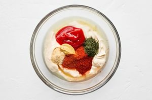 secret burger sauce being made with ketchup, garlic powder, pickle juice, dill, lime juice, paprika, cayenne, and mustard
