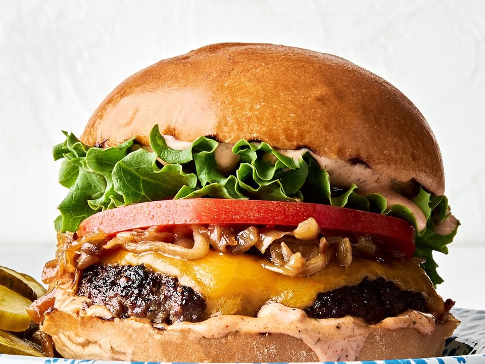 A classic juicy cheese burger topped with secret sauce, melted cheese, caramelized onion, tomato, lettuce and pickles