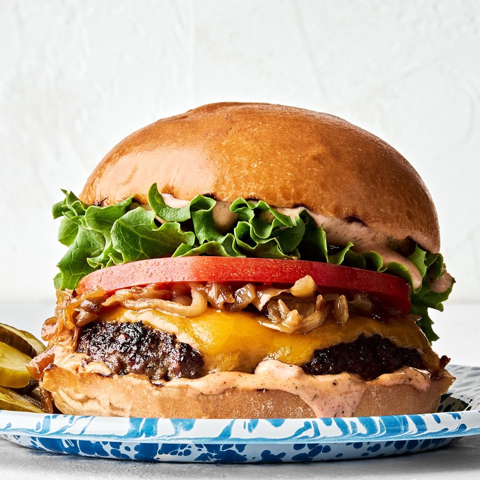 A classic juicy cheese burger topped with secret sauce, melted cheese, caramelized onion, tomato, lettuce and pickles