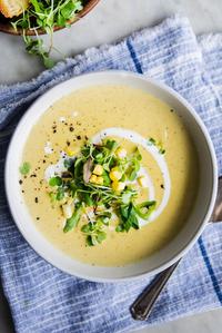 a bowl of Corn and Leek Bisque with cream and a spoon