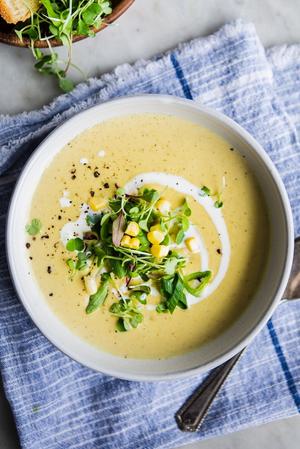 a bowl of Corn and Leek Bisque with cream and a spoon