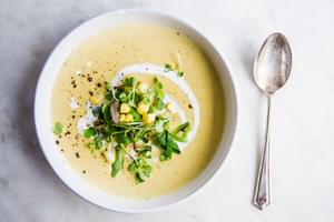a bowl of Corn and Leek Bisque with cream and a spoon