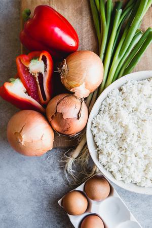 ingredients laid out for Ham and Pineapple Fried Rice, eggs, onions, day old rice, bell peppers and green onions