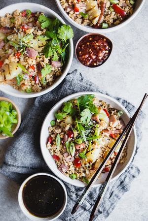 3 bowls of Ham and Pineapple Fried Rice with chili sauce and cilantro