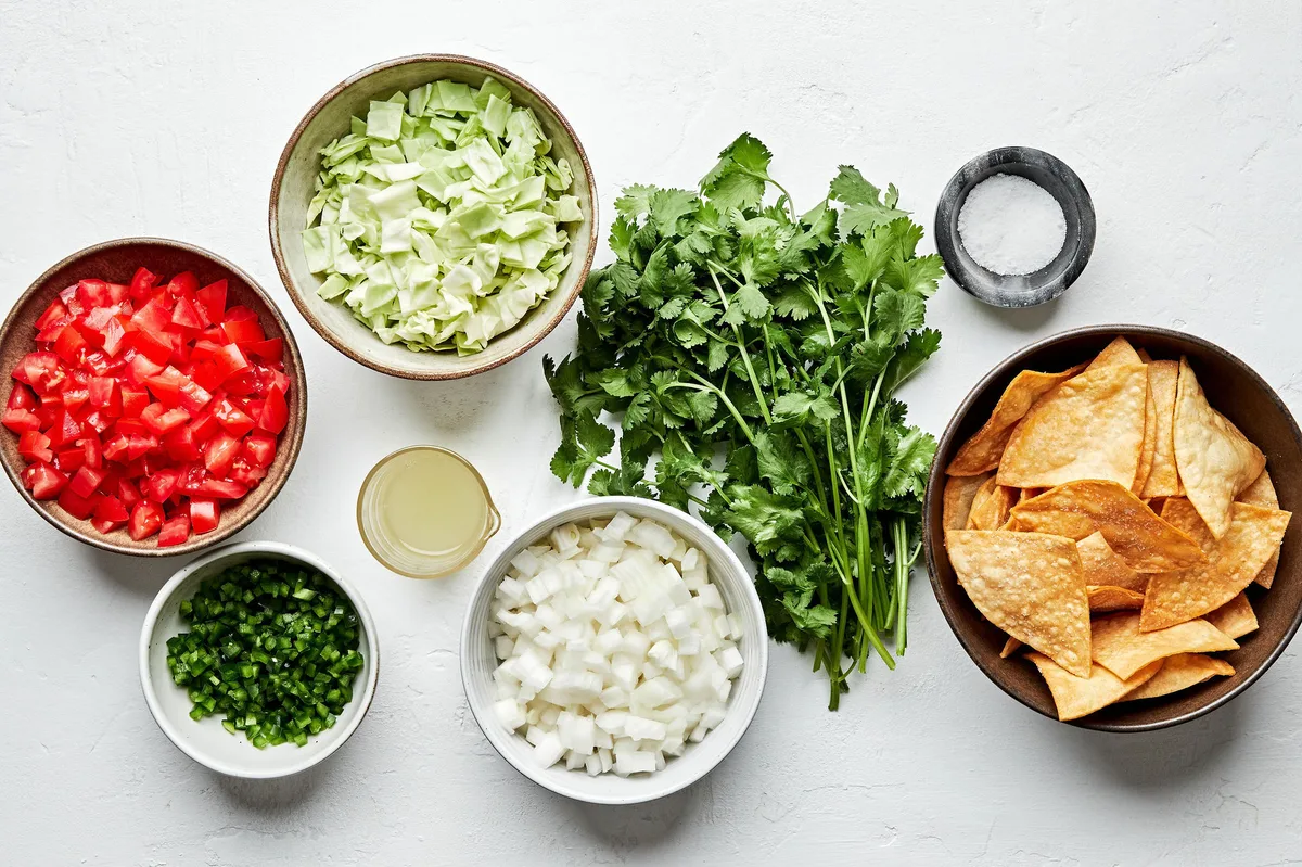 tomatoes, onion, cabbage, jalapenos, cilantro, lime juice, salt and tortilla chips to make pico de gallo with cabbage