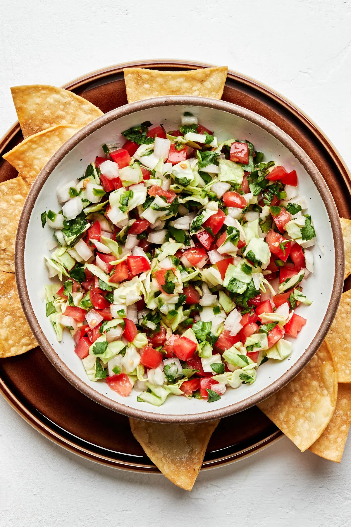 a bowl of fresh homemade pico de gallo served with tortilla chips for serving