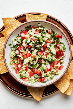 a bowl of fresh homemade pico de gallo served with tortilla chips for serving