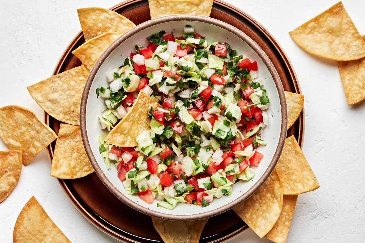 a bowl of fresh homemade pico de gallo served with tortilla chips for serving