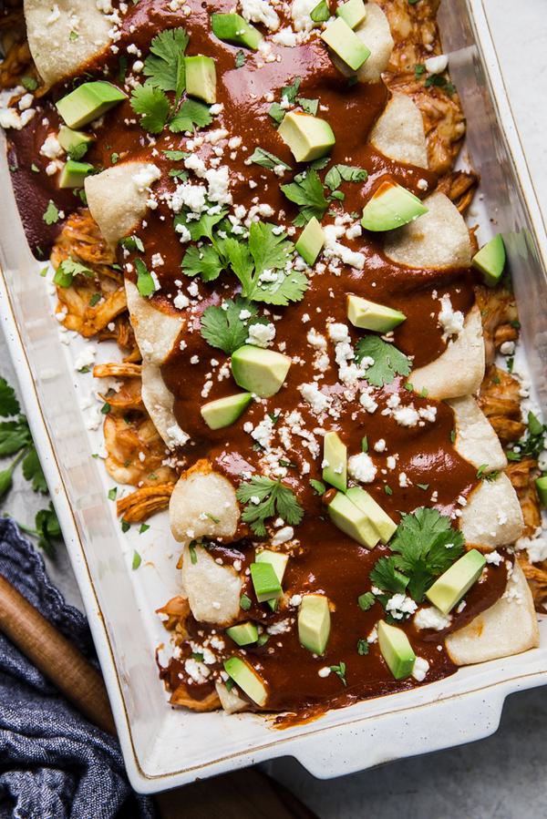 simple chicken mole enchiladas in a baking dish with avocado