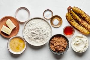 flour, baking soda, salt, butter, brown sugar, eggs, bananas, sugar, mascarpone and maple syrup in bowls to make banana bread
