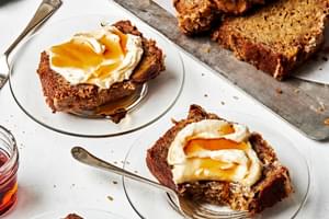 slices of the best homemade banana bread on plates slathered with maple mascarpone and a drizzle of extra maple syrup