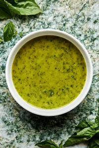 homemade basil vinaigrette in a small bowl made with garlic, lemon zest & Juice, basil, olive oil, sugar, salt and pepper