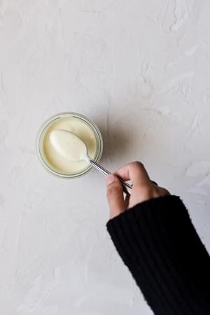 hand mixing aioli in a jar