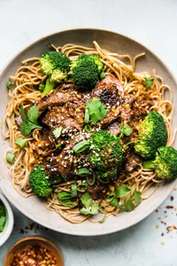 Broccoli and beef soba noodles in a bowl with sesame seeds