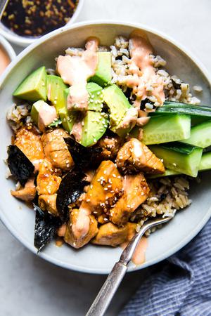 Chicken teriyaki Sushi Bowl with cucumbers , sesame seeds, avocado, seaweed and sriracha mayo