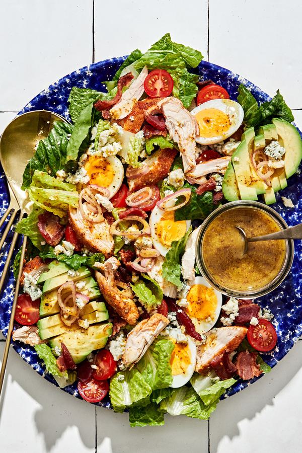 classic cobb salad made with romaine, chicken, hard boiled eggs, bacon, tomatoes, blue cheese, avocado & shallot vinaigrette