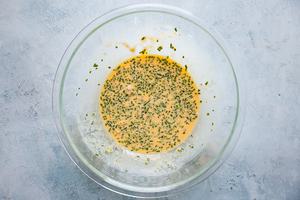 beaten eggs in a bowl with minced chives, salt and pepper