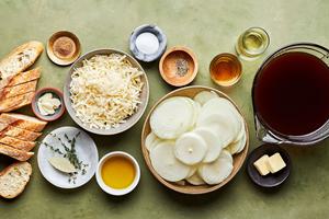 olive oil, butter, spices, wine, beef stock, port, baguette and Gruyère cheese bowls to make french onion soup
