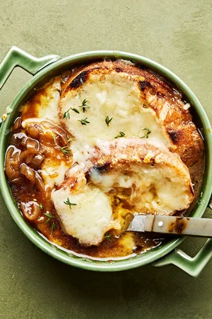 a bowl of homemade french onion soup topped with warm, bubbly Gruyère cheese