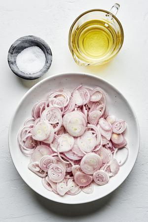 sliced raw shallots, vegetable oil and kosher salt in bowls on the counter to make fried shallots
