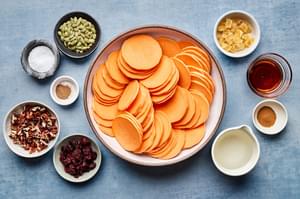 sweet potatoes, pumpkin seeds, candied ginger, dried cranberries, pecans, spices, maple syrup and coconut oil in bowls