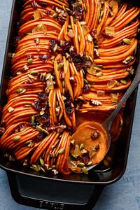healthy sweet potato casserole  topped with  pumpkin seeds, candied ginger, dried cranberries & chopped pecans