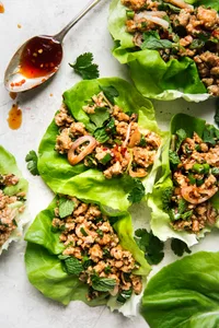 Larb Lettuce Cups with ground chicken a spoon with sauce