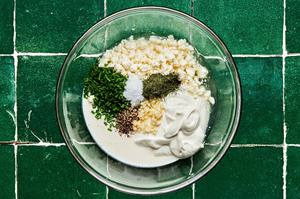 feta, heavy cream, lemon juice, chives, garlic, dill, sour cream, vinegar, salt, and pepper in a glass bowl