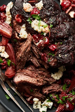 Pot Roast with Tart Cherry-Black Pepper Sauce topped with parsley and gorgonzola cheese