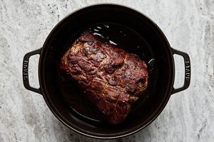 roast seasoned with salt being browned in a dutch oven