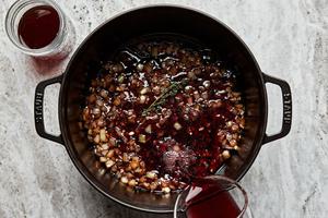 onion, garlic, wine, beef stock, and thyme cooking in a dutch oven