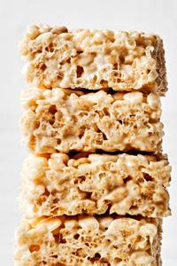 4 homemade rice crispy treats stacked on top of each other made with butter, marshmallows, vanilla and rice krispie cereal