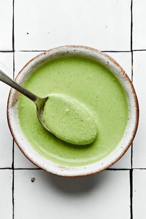 homemade green goddess dressing in a bowl being scooped with a spoon