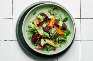Roasted beet salad made with beets, carrots, spring salad mix and micro greens drizzled with green goddess dressing