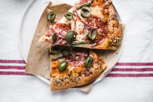 homemade Pizza slices with Honey, jalapeños, red onions and everything bagel crust on a plate