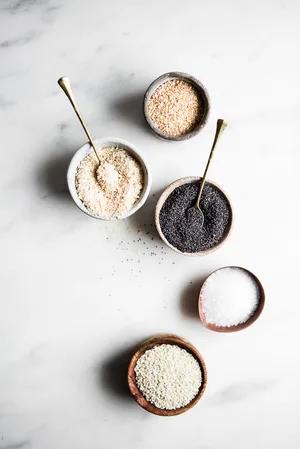 ingredients laid out for everything bagel seasoning, poppy seeds, sesame seeds, sea salt, minced onion and minced garlic