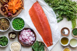 salmon on parchment, with peas, radishes, carrots, mint, basil, oil and garlic.