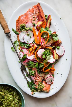 Roasted Salmon With Spring Pesto on a platter with radishes, mint, cilantro and carrot ribbons
