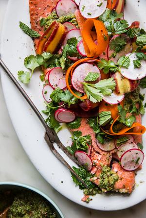 Roasted Salmon With Spring Pesto on a platter with radishes, mint, cilantro and carrot ribbons