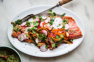 Roasted Salmon With Spring Pesto on a platter with radishes, mint, cilantro and carrot ribbons