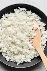 homemade sushi rice seasoned with salt, rice vinegar and sugar in a bowl with a wooden spoon