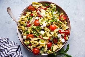 tortellini pasta salad with pesto, mozzarella, roasted red bell peppers, cherry tomatoes and shredded chicken