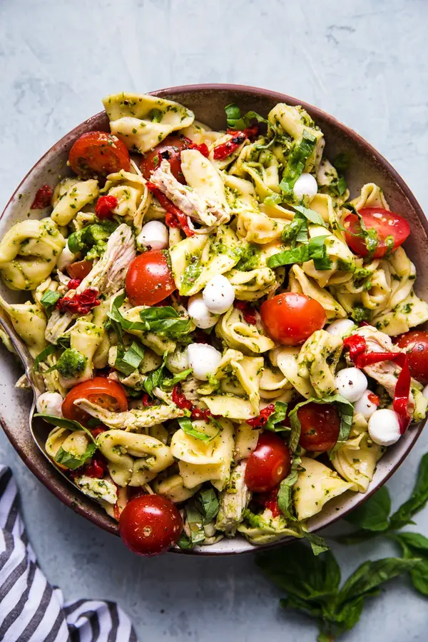 tortellini pasta salad with tomatoes, and basil and pesto