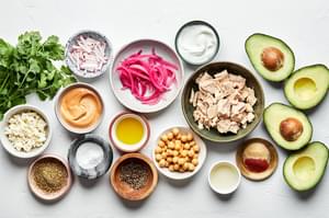 avocados, tuna, Greek yogurt, chickpeas, spices, pickled red onions, feta, cilantro and vegan cashew cheese sauce in bowls
