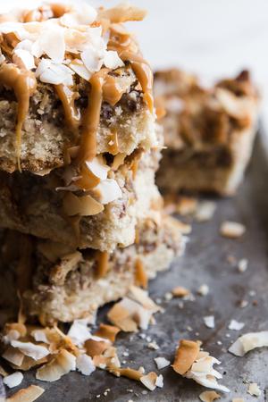 Coconut Pecan Caramel Bars being drizzled with caramel