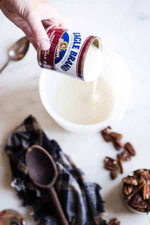sweetened condensed milk being poured into a bowl