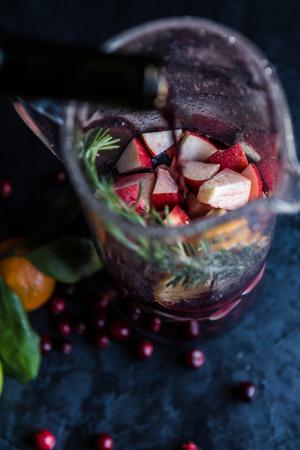 red wine being poured into a pitcher with fruit in it for red sangria